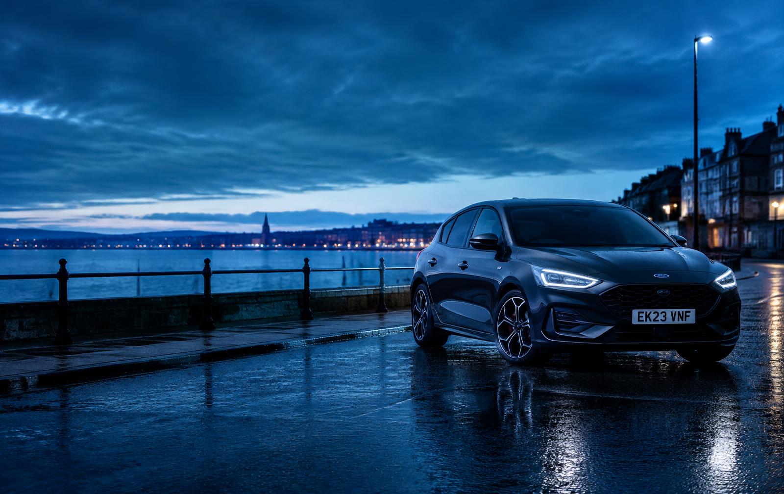 A modern car parked on a wet UK seafront at dusk